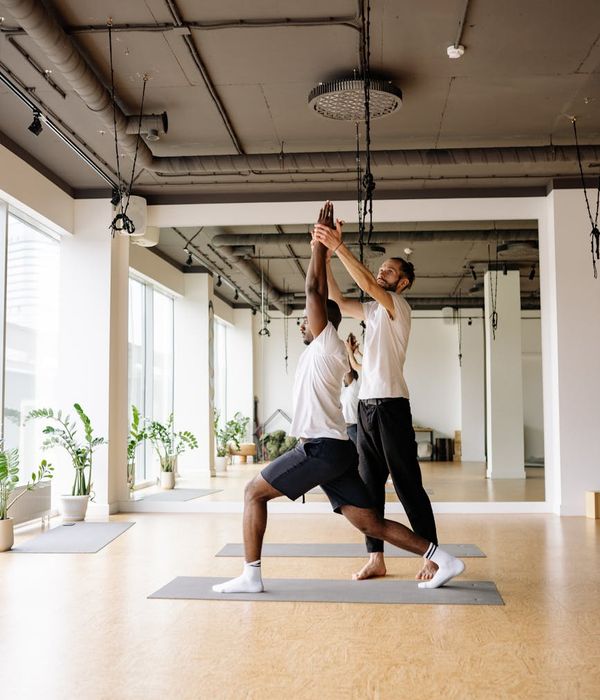 Man performing a controlled strength exercise in a bright studio.